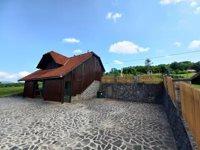 a building with a stone floor next to a fence at Vineyard Cottage Maleric with Pool Access in Dragatuš