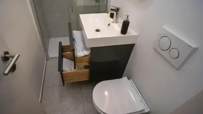 a bathroom with a white sink and a toilet at Sunnyside Apartment in the City Center in Ljubljana