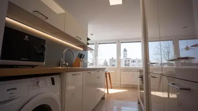 a kitchen with a washer and dryer in a kitchen at Sunnyside Apartment in the City Center in Ljubljana