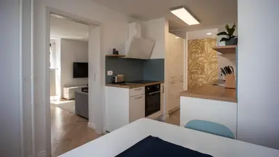 a kitchen with white cabinets and a blue chair at Sunnyside Apartment in the City Center in Ljubljana