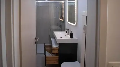 a bathroom with a white sink and a toilet at Sunnyside Apartment in the City Center in Ljubljana