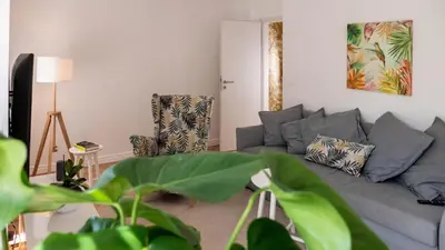 a living room with a gray couch and two chairs at Sunnyside Apartment in the City Center in Ljubljana