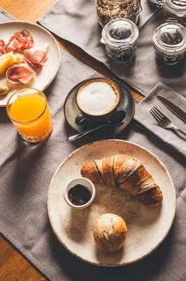 a table with two plates of food with bread and orange juice at Villa Vajta in Dobrovo