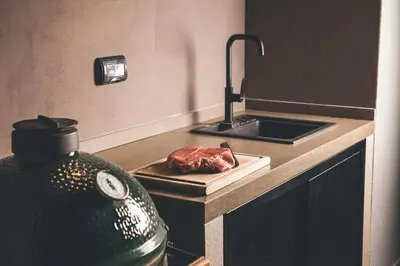 a kitchen with a counter with a piece of meat on a cutting board at Villa Vajta in Dobrovo