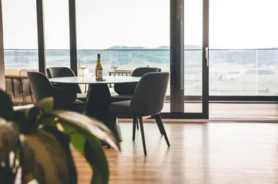 a table with chairs and a bottle of wine on it at Villa Vajta in Dobrovo