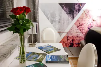 a vase with red roses sitting on a table at Relax & Beautiful View in Slovenj Gradec