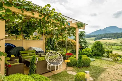 a gazebo with a swing in a garden at Relax & Beautiful View in Slovenj Gradec