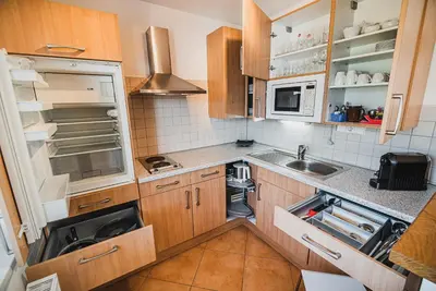 a small kitchen with wooden cabinets and a sink at Apartment pri Povhih in Slovenske Konjice