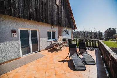 a patio with chairs and a table and a building at Apartment pri Povhih in Slovenske Konjice