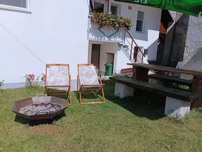 two chairs and a table in front of a building at Apartma Hči planin in Bovec