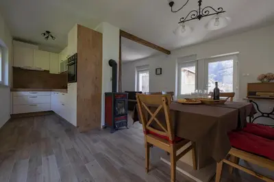 a kitchen and a dining room with a table and chairs at Apartma Hči planin in Bovec