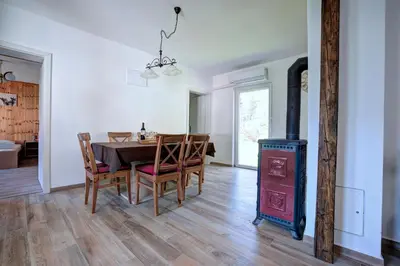a dining room with a table and a wood stove at Apartma Hči planin in Bovec