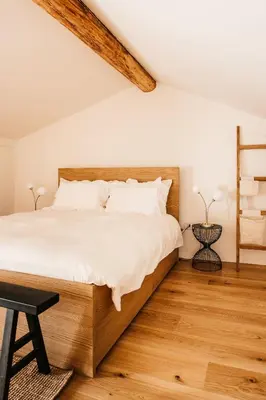 a bedroom with a large bed with a wooden headboard at Grad Štanjel House in Štanjel