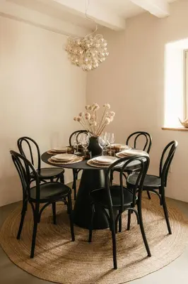 a dining room table with black chairs and a chandelier at Grad Štanjel House in Štanjel