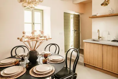 a kitchen and dining room with a table and chairs at Grad Štanjel House in Štanjel