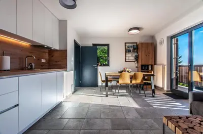 a kitchen and dining room with a table and chairs at Apartma Kadulja Golte in Mozirje