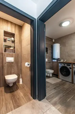 a bathroom with a toilet and a washing machine at Apartma Kadulja Golte in Mozirje