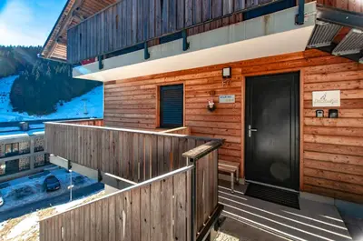 a wooden house with a door on a balcony at Apartma Kadulja Golte in Mozirje
