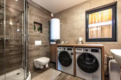 a bathroom with a washing machine and a sink at Apartma Kadulja Golte in Mozirje