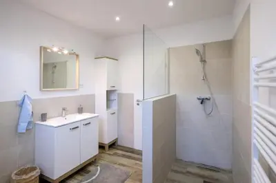 a white bathroom with a sink and a shower at Central Garden House (family friendly!) in Postojna