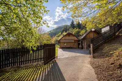 a fence next to a barn with a driveway at Hiška pod Rudnico 1 in Podčetrtek