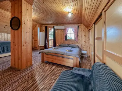a bedroom with a bed in a wooden cabin at APARTMA-SPA NATURA in Sveti Jurij ob Ščavnici