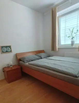 a bedroom with a bed and a window at Apartma Knap Velenje in Velenje