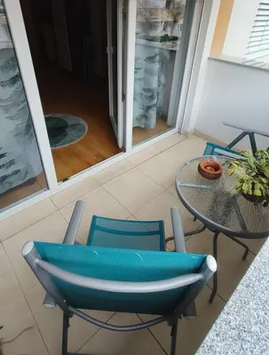 a blue chair and a table and a table and a glass table at Apartma Knap Velenje in Velenje