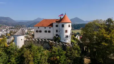 a castle on top of a hill with a city at Apartma Knap Velenje in Velenje