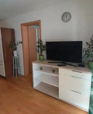 a living room with a tv on a white dresser at Apartma Knap Velenje in Velenje