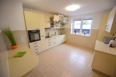 a kitchen with white cabinets and a table in it at Holiday Home Toplica Natura with natural thermal Bath in Cerklje ob Krki