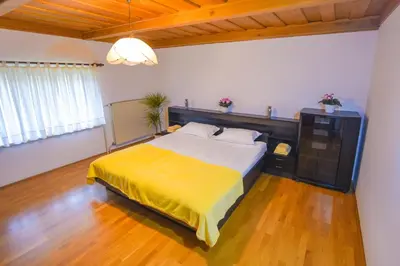 a bedroom with a large bed with a yellow blanket at Holiday Home Toplica Natura with natural thermal Bath in Cerklje ob Krki