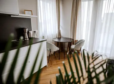 a kitchen with a table and chairs in a room at Bresidence Apartments with free private parking in Ljubljana
