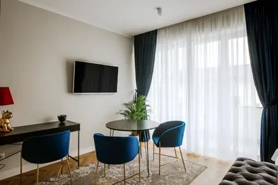 a living room with a table and blue chairs at Bresidence Apartments with free private parking in Ljubljana
