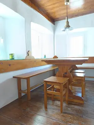 a dining room with a table and a bench at počitniška hiška MEDVEJKE in Slappe dʼIdria