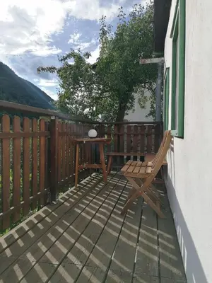 a wooden deck with a table and a bench at počitniška hiška MEDVEJKE in Slappe dʼIdria