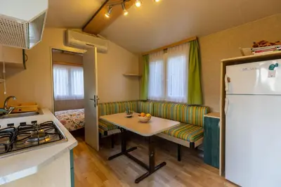 a kitchen with a couch and a table and a refrigerator at Hiška pod Rudnico 2 in Podčetrtek