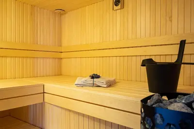 a sauna with a towel sitting on a wooden floor at Karst house Žan Pliskovica with private pool in Dutovlje