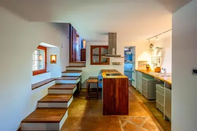 a kitchen with wooden benches and a table in it at Karst house Žan Pliskovica with private pool in Dutovlje