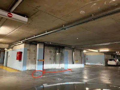 an empty parking garage with a red hose in it at Apartment Green - Grey in Ljubljana