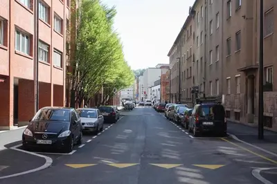a city street with cars parked on the sides of the road at Apartment Green - Grey in Ljubljana
