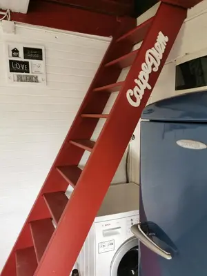 a red ladder in a garage next to a washing machine at KOZJANSKA KOČA in Podčetrtek