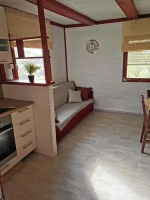 a living room with a couch and a clock on the wall at KOZJANSKA KOČA in Podčetrtek