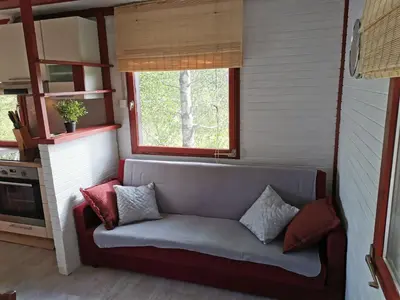 a couch in a small room with a window at KOZJANSKA KOČA in Podčetrtek