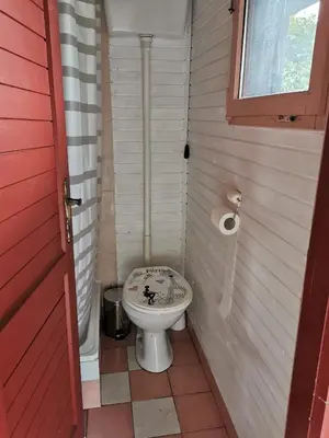 a small bathroom with a toilet and a red door at KOZJANSKA KOČA in Podčetrtek