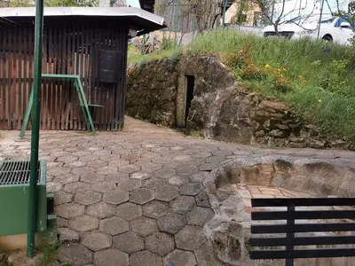 a stone walkway with a bench in front of a building at KOZJANSKA KOČA in Podčetrtek