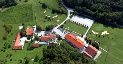 an aerial view of a building with a field and trees at KOZJANSKA KOČA in Podčetrtek