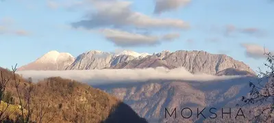 a view of a mountain range with clouds in the foreground at Moksha Slovenia in Tolmin