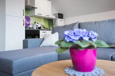 a pink vase with blue flowers on a table at Apartma Lida 2 in Bled