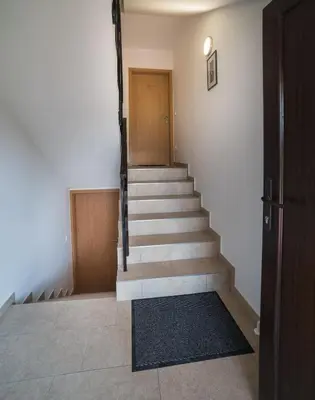a staircase in a building with a door and a stair mat at Apartma Lida 1- mirna lokacija, brezplačno parkirišče, 10 minut hoje do jezera in gradu in Bled